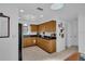 Well-lit kitchen featuring wood cabinets, black countertops, and tile flooring at 1742 Mississippi Ne Ave, St Petersburg, FL 33703
