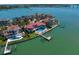 Aerial view showcasing waterfront homes with pools and private docks, nestled along a scenic coastline at 26 Sunset Bay Drive, Belleair, FL 33756
