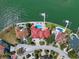 Aerial view of waterfront homes with pools, lush landscaping, and private docks on a beautiful coastline at 26 Sunset Bay Drive, Belleair, FL 33756