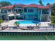 Waterfront home has a private pool, patio seating, and steps to a large backyard with bay views at 26 Sunset Bay Drive, Belleair, FL 33756