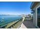 Wide water view from the balcony featuring black iron railings, tile floor, and exterior lighting fixtures at 26 Sunset Bay Drive, Belleair, FL 33756