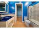 Stylish bathroom features a blue glass bowl sink and a shower with tile surround at 26 Sunset Bay Drive, Belleair, FL 33756