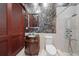 Elegant bathroom featuring a rain shower, a vessel sink on a rich wood vanity, and custom decorative walls at 26 Sunset Bay Drive, Belleair, FL 33756