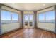 Light-filled room featuring hardwood flooring, bay windows, and french doors with scenic water views at 26 Sunset Bay Drive, Belleair, FL 33756