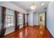 Light-filled bedroom features hardwood floors, three arched windows, and access to an ensuite bathroom at 26 Sunset Bay Drive, Belleair, FL 33756