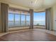 Waterfront bedroom with floor-to-ceiling windows showcasing stunning coastal views and a hardwood floor at 26 Sunset Bay Drive, Belleair, FL 33756