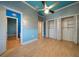 Bedroom featuring light blue walls, wood floors, ceiling fan and a closet space at 26 Sunset Bay Drive, Belleair, FL 33756