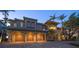 Elegant multi-story home with a three-car garage, brick driveway, and lush tropical landscaping at 26 Sunset Bay Drive, Belleair, FL 33756