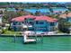 Waterfront home with a red tile roof, multi-level balconies, a swimming pool, and a private dock at 26 Sunset Bay Drive, Belleair, FL 33756