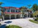Stunning waterfront home with a red tile roof, covered parking, and meticulously landscaped grounds at 26 Sunset Bay Drive, Belleair, FL 33756