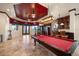 Spacious game room with a billiard table, wet bar, and large windows providing ample natural light and water views at 26 Sunset Bay Drive, Belleair, FL 33756