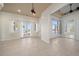 Bright, open-concept living room with tile flooring, access to outdoor patios, and beautiful water views at 26 Sunset Bay Drive, Belleair, FL 33756