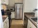 Compact kitchen featuring stainless steel appliances, granite countertops, and tiled flooring at 501 Knights Run Ave # 2119, Tampa, FL 33602