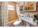 Retro bathroom features a tiled tub, pedestal sink, and decorative accents at 6226 Hampton N Ct, St Petersburg, FL 33710