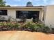 Charming home exterior featuring a landscaped front yard with vibrant flowers and well-maintained plants, enhancing curb appeal at 6226 Hampton N Ct, St Petersburg, FL 33710