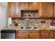 Close up view of a kitchen area featuring wooden cabinetry, granite countertops and tile backsplash at 6226 Hampton N Ct, St Petersburg, FL 33710