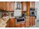 Close up view of a kitchen area featuring wooden cabinetry, granite countertops, tile backsplash and stainless appliances at 6226 Hampton N Ct, St Petersburg, FL 33710