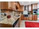 Modern kitchen featuring granite countertops, stainless steel appliances, tile backsplash and wooden cabinetry at 6226 Hampton N Ct, St Petersburg, FL 33710