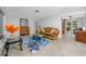 Inviting living room with a leather sofa, glass coffee table, and doorway to the backyard at 6226 Hampton N Ct, St Petersburg, FL 33710