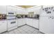Functional kitchen featuring white cabinets and appliances with ample counter space at 8954 Antigua Dr, Seminole, FL 33777