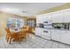Bright kitchen with white appliances, tile flooring, and an adjacent dining area at 8954 Antigua Dr, Seminole, FL 33777