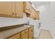 A laundry room with white, front-loading washer and dryer next to cream colored cabinets and sink at 4023 W Horatio St, Tampa, FL 33609