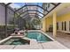 A screened-in pool area that includes a jacuzzi, waterfall features, and a yellow exterior at 4023 W Horatio St, Tampa, FL 33609