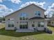 Back exterior featuring large windows, patio, and manicured yard with an AC unit at 4351 Highcroft Dr, Wesley Chapel, FL 33545