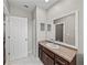 Bathroom featuring dark wood vanity, large mirror and neutral color palette at 4351 Highcroft Dr, Wesley Chapel, FL 33545