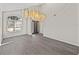 Large open entryway showing grey wood flooring, high ceilings, and a unique modern chandelier fixture at 4351 Highcroft Dr, Wesley Chapel, FL 33545