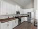Bright kitchen featuring white cabinets, stainless steel appliances, and wood-look floors at 4351 Highcroft Dr, Wesley Chapel, FL 33545