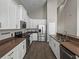Galley style kitchen featuring stainless steel appliances, white cabinets and plenty of counter space at 4351 Highcroft Dr, Wesley Chapel, FL 33545