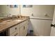Bathroom vanity featuring granite countertop, white cabinetry, and decorative starfish wall hangings at 5975 Terrace Park N Dr # 102, St Petersburg, FL 33709