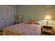 Inviting bedroom with lamps, closet and floral patterned bedspread at 5975 Terrace Park N Dr # 102, St Petersburg, FL 33709