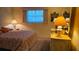 Comfortable bedroom featuring a dresser with lamps and a brightly patterned bedspread at 5975 Terrace Park N Dr # 102, St Petersburg, FL 33709