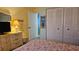 Bedroom featuring closet and adjacent bath with colorful floral bedspread at 5975 Terrace Park N Dr # 102, St Petersburg, FL 33709