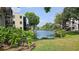 Scenic exterior view of waterfront property with well-maintained landscaping and lush green trees at 5975 Terrace Park N Dr # 102, St Petersburg, FL 33709