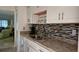 Bright kitchen with stainless steel sink, granite countertops, and white cabinetry at 5975 Terrace Park N Dr # 102, St Petersburg, FL 33709