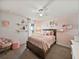 Charming bedroom with a full-sized bed, pink accents, and natural light from a large window at 6307 Bridgevista Dr, Lithia, FL 33547