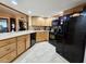 Traditional kitchen featuring wooden cabinets and modern black appliances and light colored flooring at 7711 Innis Ct, St Petersburg, FL 33709