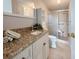 Bathroom features granite counters, tiled walk-in shower with seat, and white cabinets at 112 Saint Pierres Way, Apollo Beach, FL 33572