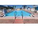 Community pool with clear blue water, surrounded by lounge chairs and palm trees at 112 Saint Pierres Way, Apollo Beach, FL 33572