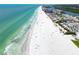 Stunning aerial view of a pristine beach with turquoise water, white sand, and nearby buildings at 17960 Gulf Blvd # 103, Redington Shores, FL 33708