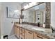 Stylish bathroom featuring granite countertop, framed mirror, and shower with glass door at 17960 Gulf Blvd # 103, Redington Shores, FL 33708
