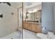 Bright bathroom featuring a glass shower, granite countertops, and light wood cabinets at 17960 Gulf Blvd # 103, Redington Shores, FL 33708