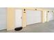 Garage and entry door for unit 103 with a white door and black welcome mat at 17960 Gulf Blvd # 103, Redington Shores, FL 33708
