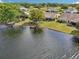 Waterfront backyard showcasing a wooden dock, a tree and lush green landscaping at 1928 E View Dr, Sun City Center, FL 33573