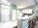 Cozy kitchen featuring white cabinets, a breakfast bar with seating, and tile flooring at 2116 Nantucket Dr # 19, Sun City Center, FL 33573