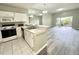 Bright kitchen featuring white cabinetry, a breakfast bar, appliances, and an open view to the living area at 2116 Nantucket Dr # 19, Sun City Center, FL 33573
