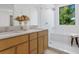 Modern bathroom featuring double sinks, wood vanity, and glass enclosed shower/tub with large window at 2702 N Woodrow Ave # 2, Tampa, FL 33602